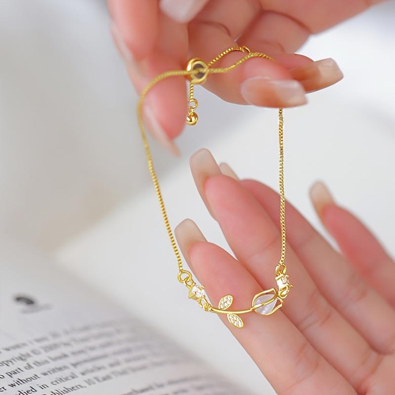 1 elegante bracciale floreale retrò da donna realizzato in acciaio inox color oro, con motivo floreale nero e bianco. È il regalo perfetto per San Valentino o per outfit casual.