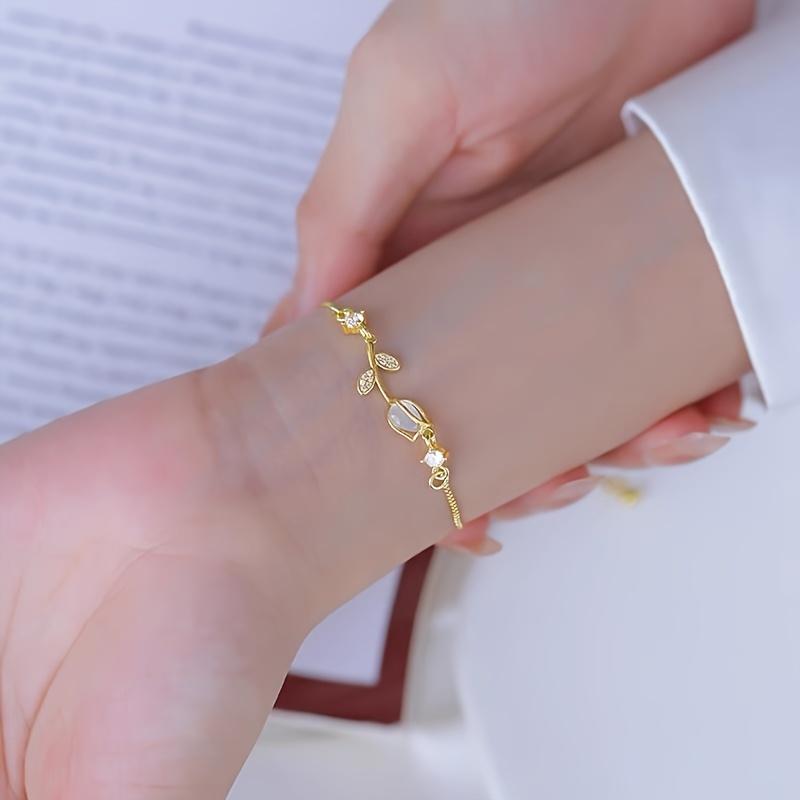 1 elegante bracciale floreale retrò da donna realizzato in acciaio inox color oro, con motivo floreale nero e bianco. È il regalo perfetto per San Valentino o per outfit casual.