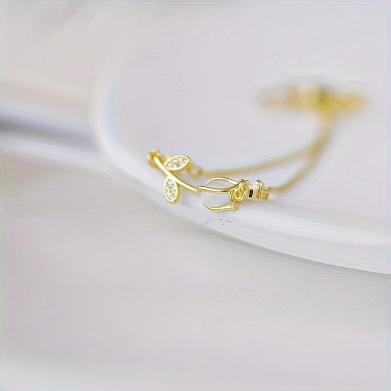 1 elegante bracciale floreale retrò da donna realizzato in acciaio inox color oro, con motivo floreale nero e bianco. È il regalo perfetto per San Valentino o per outfit casual.